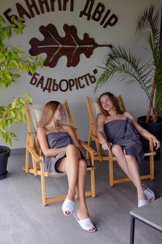 Дві жінки відпочивають і спілкуються на веранді після бані на дровах у Банному Дворі в Рівному